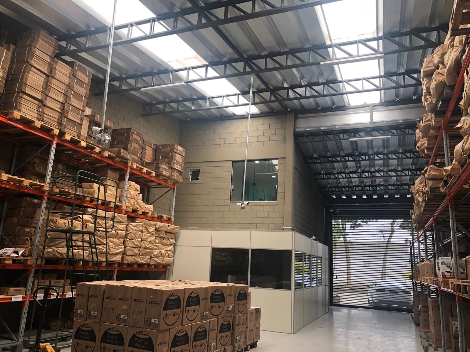Galpão da fábrica Vibra Vert por dentro, com paletes e prateleiras de estoque
